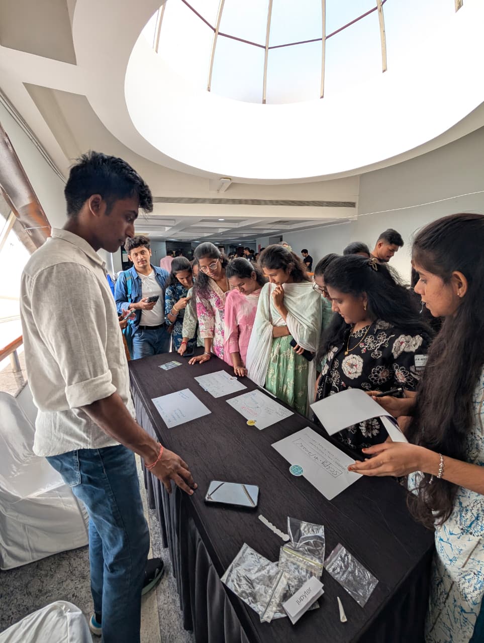 People gathered around the SciPy India booth table, reading the signs